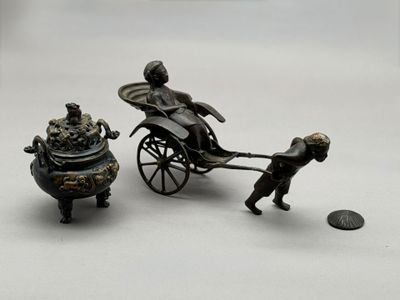 figurine représentant un homme tirant une calèche avec un chien