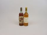 deux bouteilles de vin posées l'une à côté de l'autre sur une surface blanche