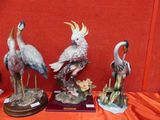 trois figurines d'oiseaux exposées sur une table