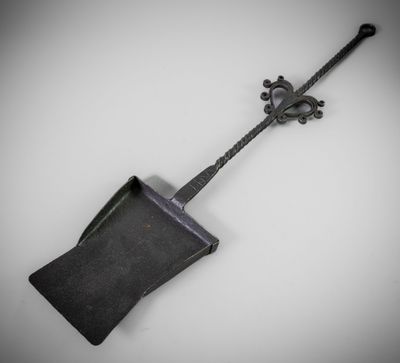a black shovel with a metal handle on a white surface