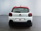 the rear end of a white car with red trims in a white room