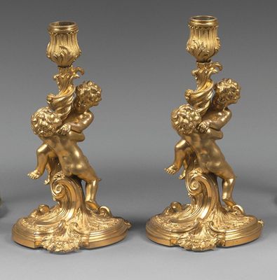 trois chandeliers en or ornés de chants et de cher chants