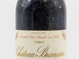 une vieille bouteille de vin posée sur une table blanche