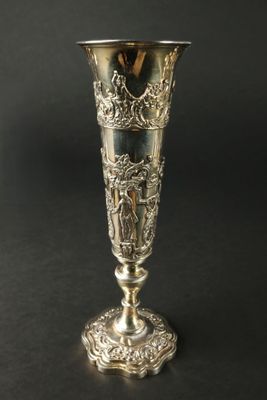 une image représentant un vase en argent posé sur une table