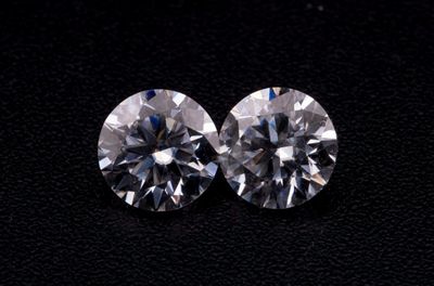une paire de diamants taille ronde sur un fond noir