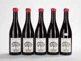 quatre bouteilles de vin sont alignées sur une surface blanche