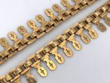 a pair of brass chain bracelets with letters and numbers on them