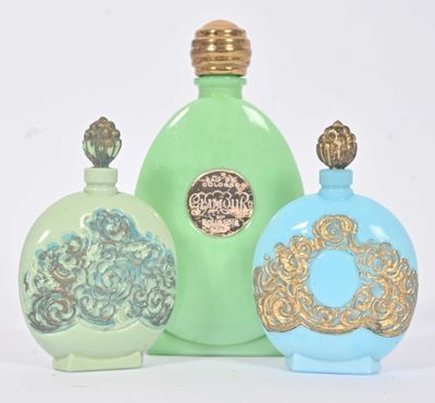 trois flacons de parfum posés les uns à côté des autres sur une surface blanche