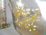 two glass vases with flowers on them on a table