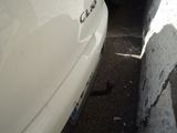 a white car parked next to a white wall
