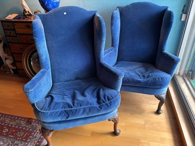 pair of blue upholstered chairs in front of a window in a living room