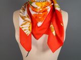 an orange and yellow scarf on a mannequin torso
