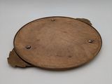 a wooden plate with a metal handle on a white surface