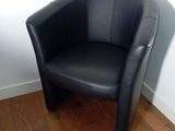a black leather chair sitting in a corner of a room