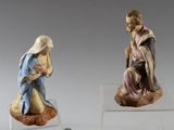 two figurines of a woman and a man sitting on a rock