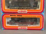 Deux cartons contenant des trains Märklin sont posés sur une table