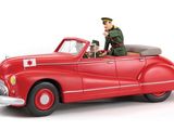 une figurine représentant un homme dans une voiture rouge sur fond blanc