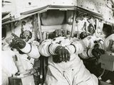 une photo en noir et blanc d'un groupe d'astronautes dans une station spatiale