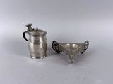 une petite coupe en argent et une autre petite coupe en argent posées sur une surface blanche