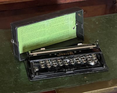 an old typewriter sitting on top of a green table