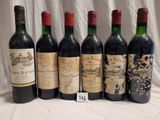 six bottles of red wine are lined up on a table