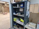 une armoire métallique sur laquelle sont posés de nombreux objets, dans un garage
