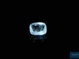 un diamant bleu sur une surface noire dans l'obscurité