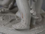 a white statue of a child on a pedestal