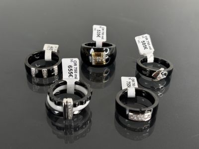 four different rings with tags on them sitting on a table