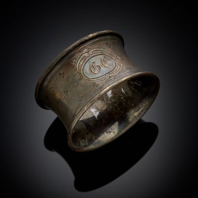 une vieille bague en argent ornée d'un motif sur un fond noir