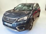 La voiture bleue est garée dans le showroom, à côté d'autres voitures.