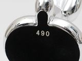 an image of a silver apple charm with a black apple on it