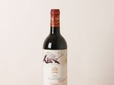 la bouteille de vin rouge est posée sur une table en bois
