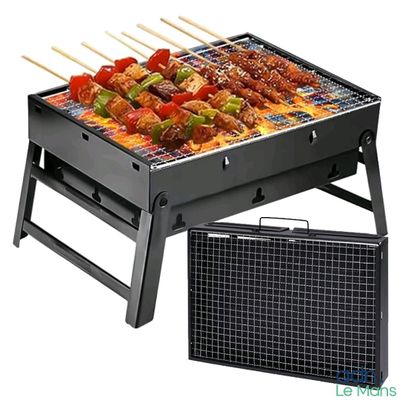 a black grill with skewers and vegetables on it