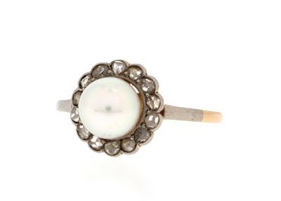 a close up of a pearl and diamond ring on a white background