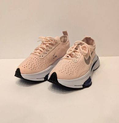 Les baskets Nike Air Max sont rose pâle et noires.
