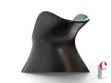 a black vase with a green stone in it