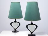 une paire de lampes de table noires avec des abat-jours verts, posées sur une surface blanche