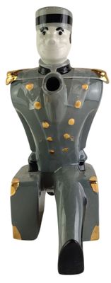 une figurine représentant un homme assis sur un tabouret