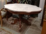 une table au plateau en marbre au milieu du salon