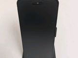the back of a black cell phone sitting on top of a white table