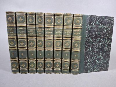 six livres verts alignés les uns à côté des autres sur une surface blanche