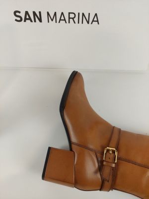 bottines en cuir beige avec des boucles et des boucles au talon