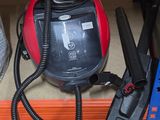 a red and black vacuum sitting on a shelf in a store