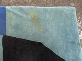 a blue and black rug with a picture of a man on a surfboard