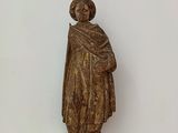 une statue représentant un homme tenant un livre sur une table en verre
