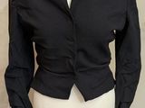 un mannequin vêtu d'une veste noire, posé sur un pied de mannequin