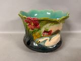 un vase en céramique orné d'un cygne et de fleurs