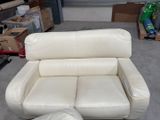 a white leather couch and ottoman in a room