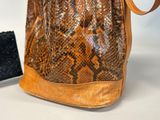 a snake skin purse with a black purse next to it